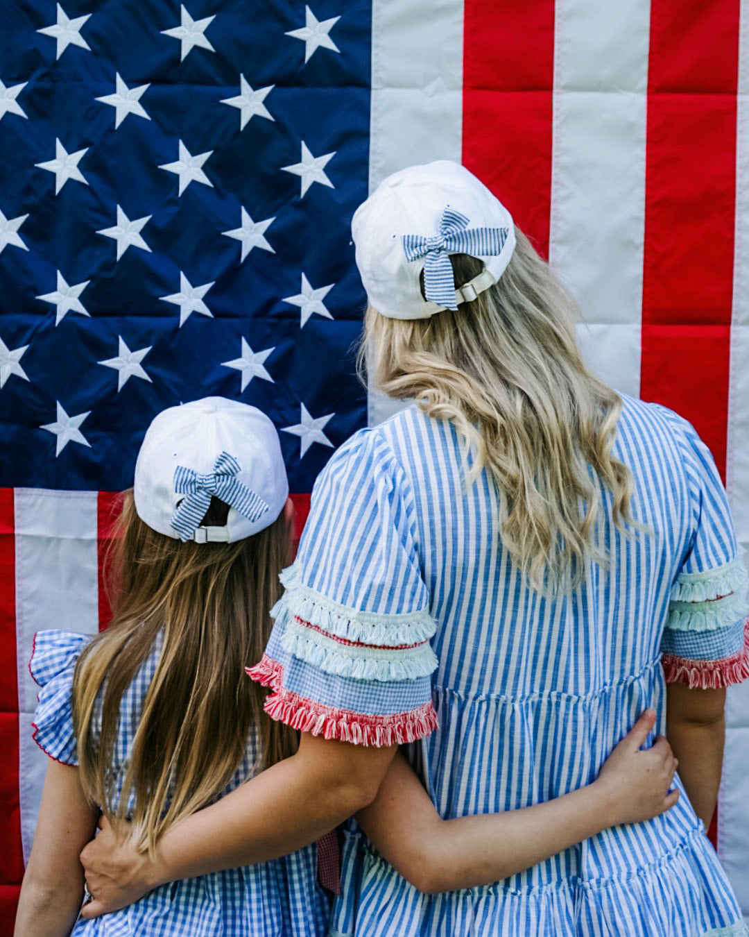 Mom and daughter wearing matching baseball hat with American flag embroidery