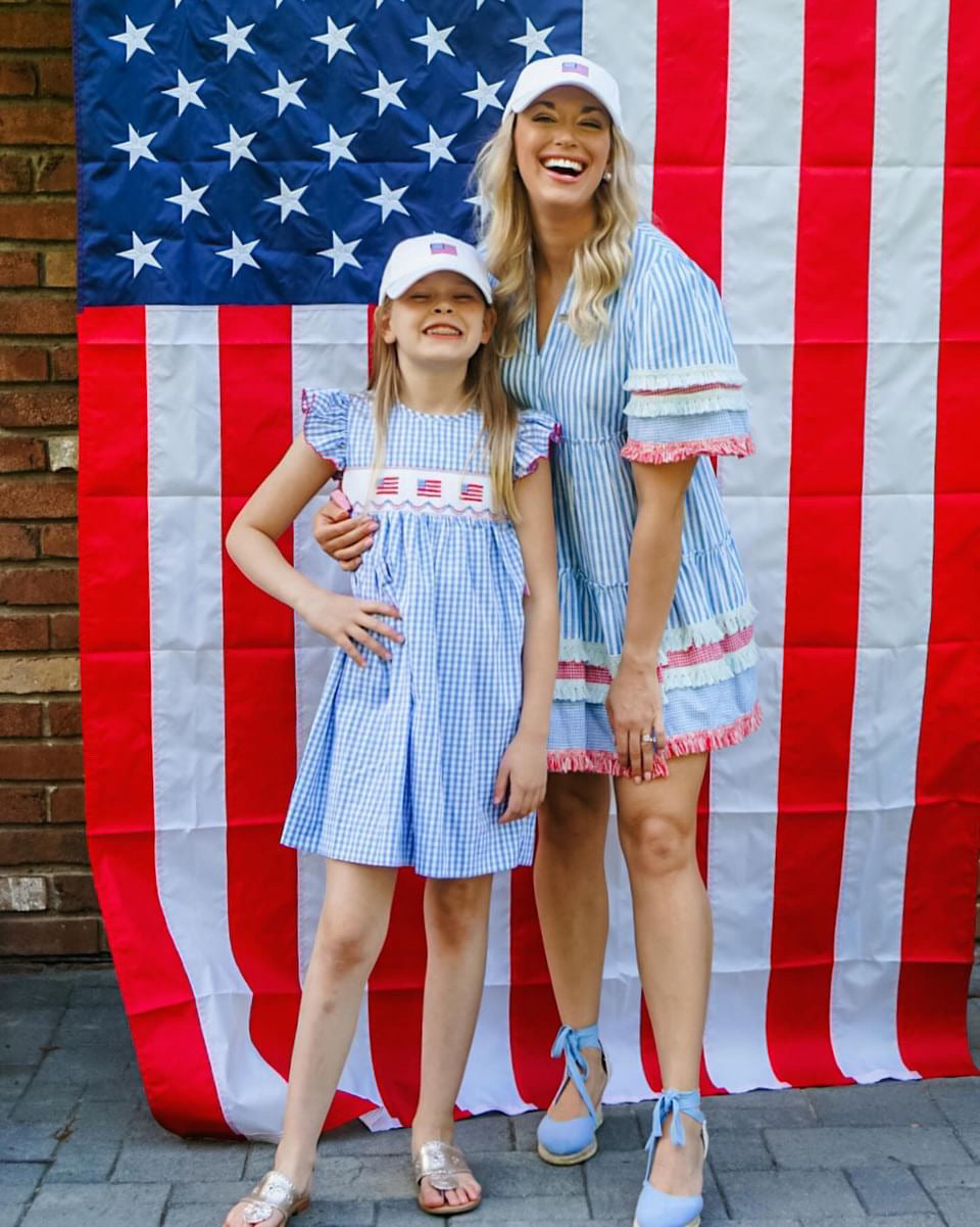 Mom and daughter wearing matching baseball hat with American flag embroidery