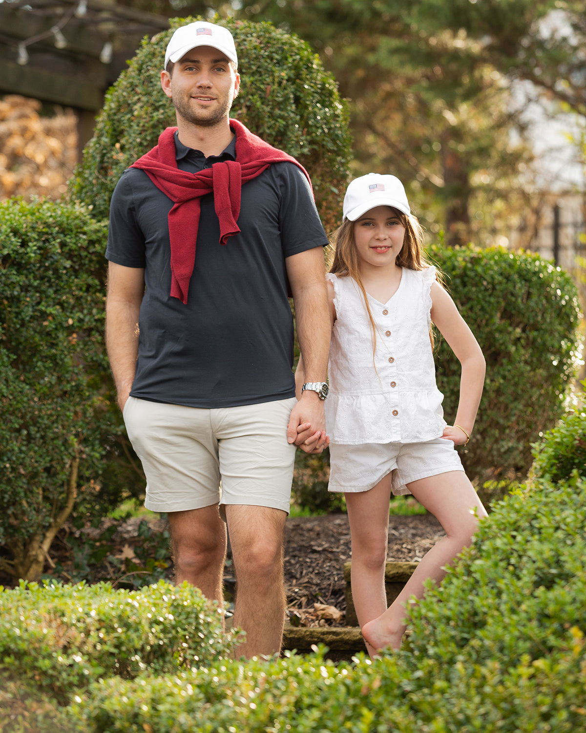 Dad and daughter wearing matching baseball hat with American flag embroidery