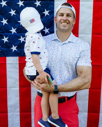 Dad and son wearing matching baseball hat with American flag embroidery