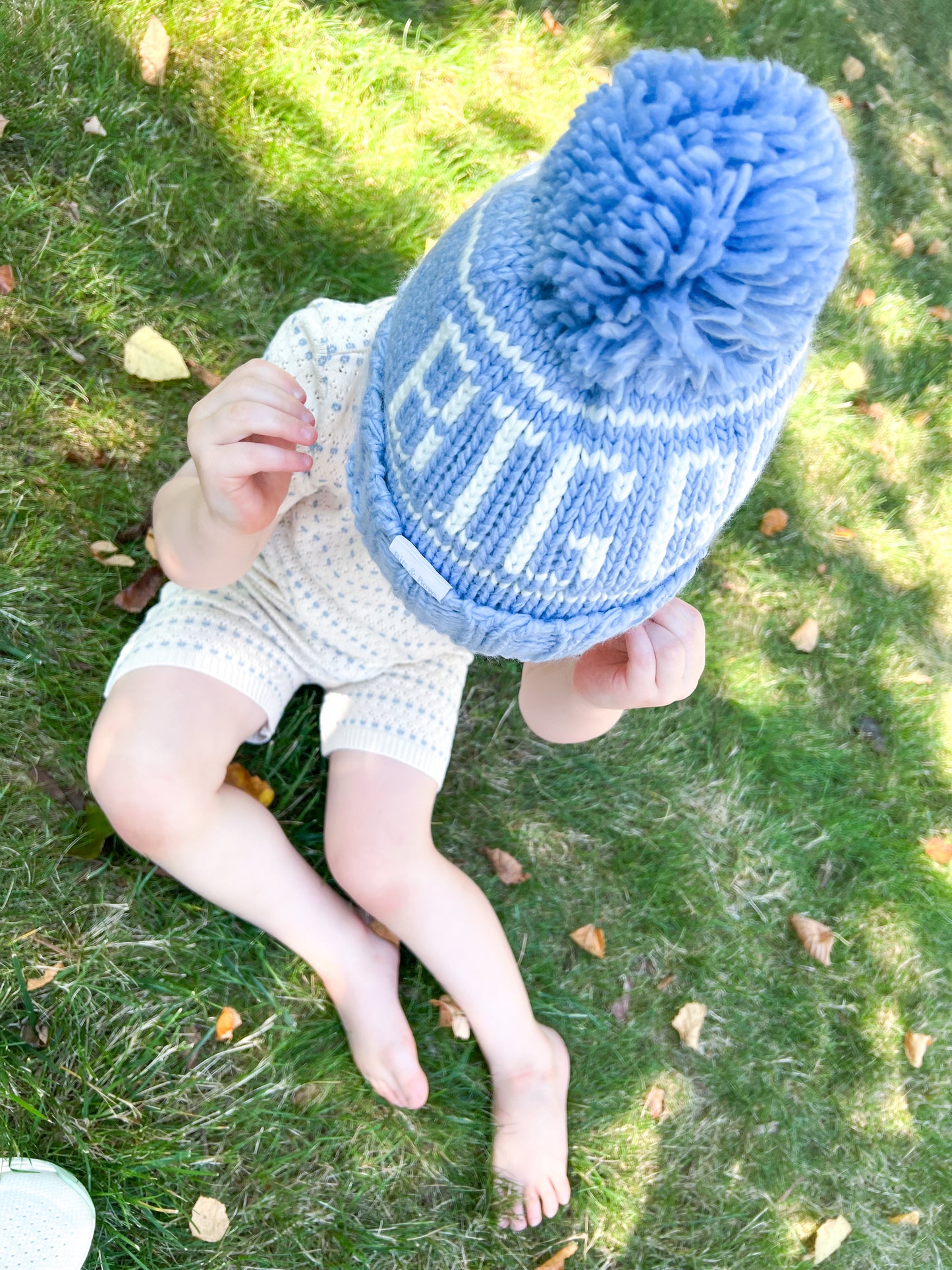 Little boy wearing a "big bro" bobble hat with pom pom