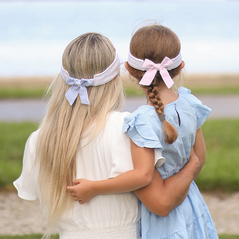 Girls wearing coordinating visors with seersucker bows on the back