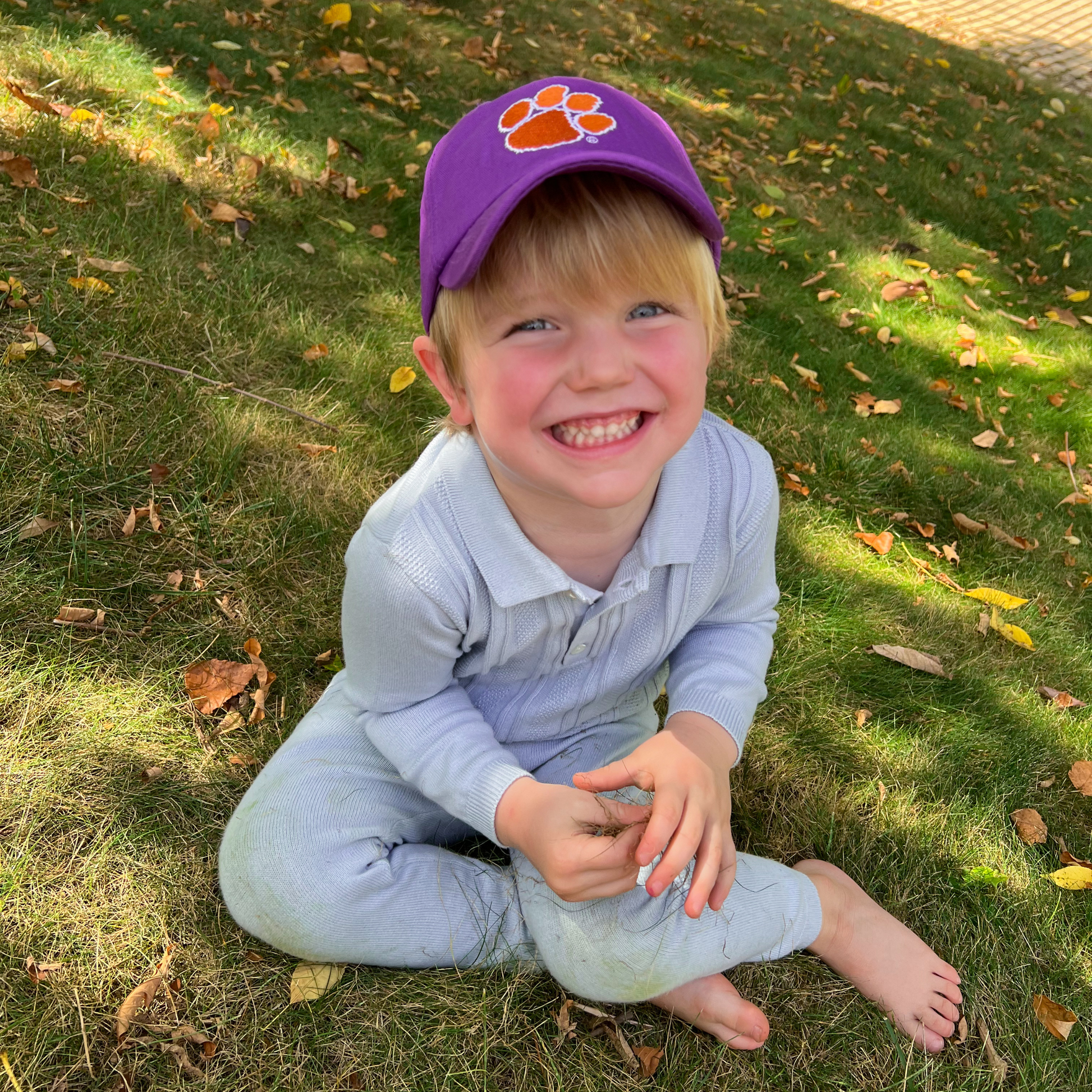 Boy wearing purple baseball hat with Clemson Tigers embroidery