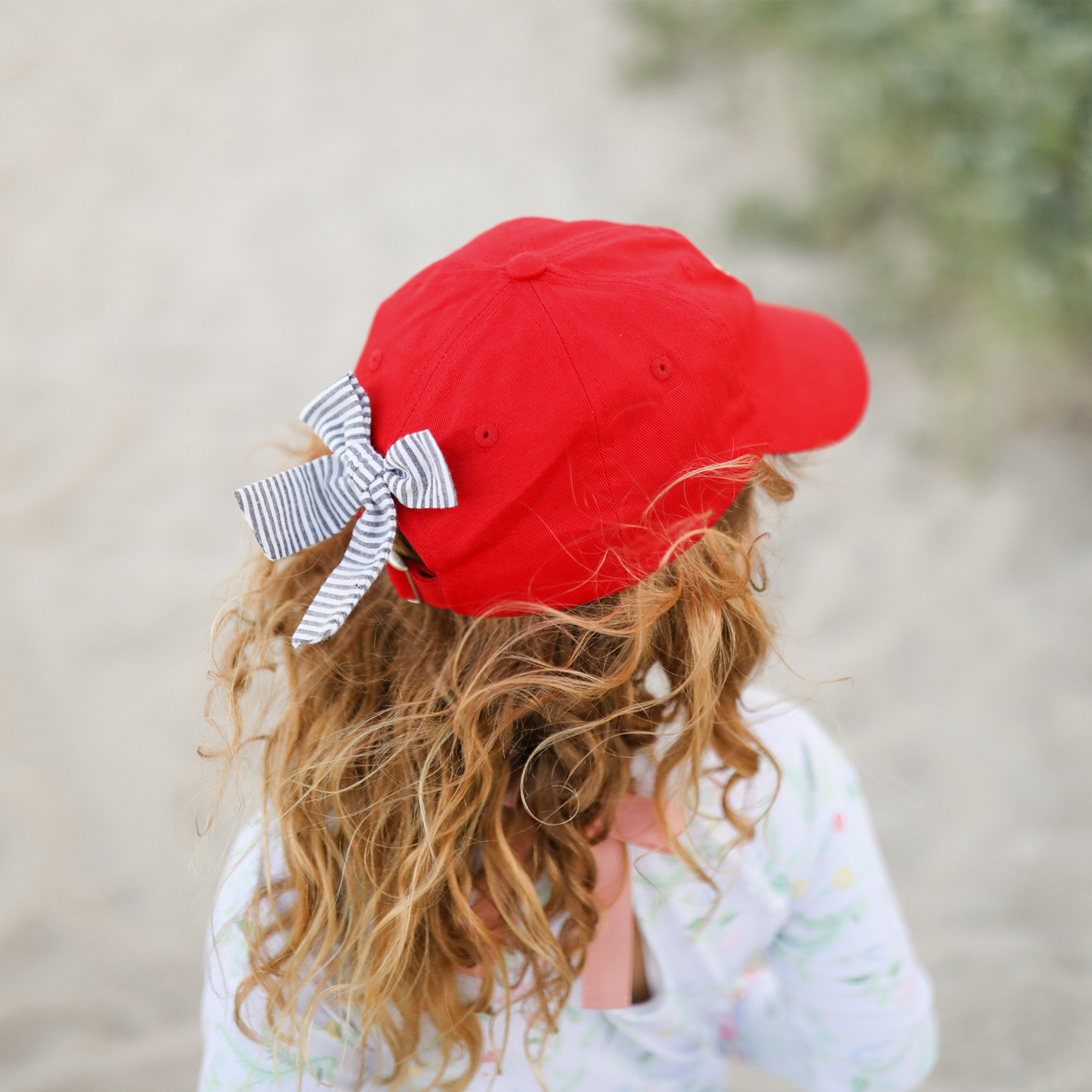 Girl wearing a red Georgia Bulldogs baseball hat with seersucker bow on the back