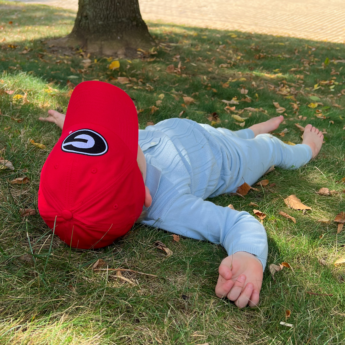 Boy wearing red baseball hat with Georgia Bulldogs logo embroidery