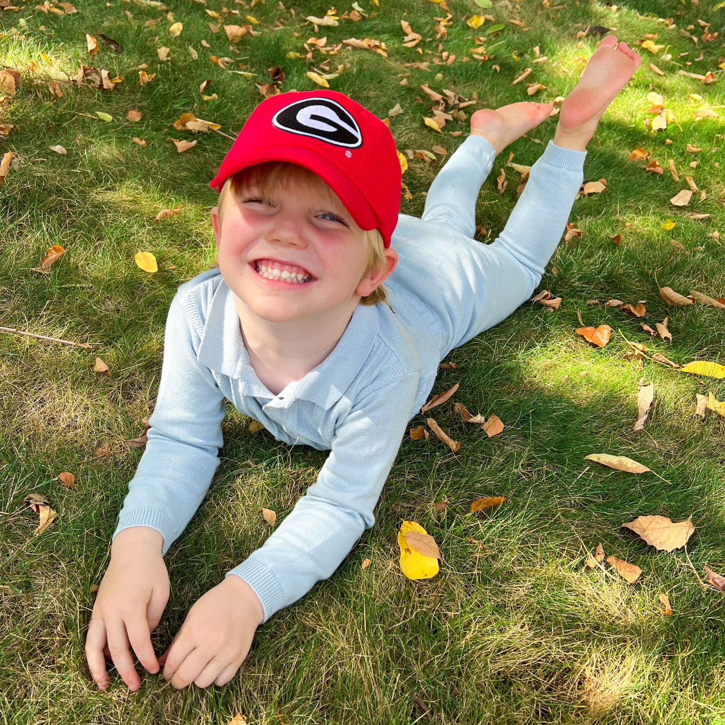 Boy wearing red baseball hat with Georgia Bulldogs logo embroidery