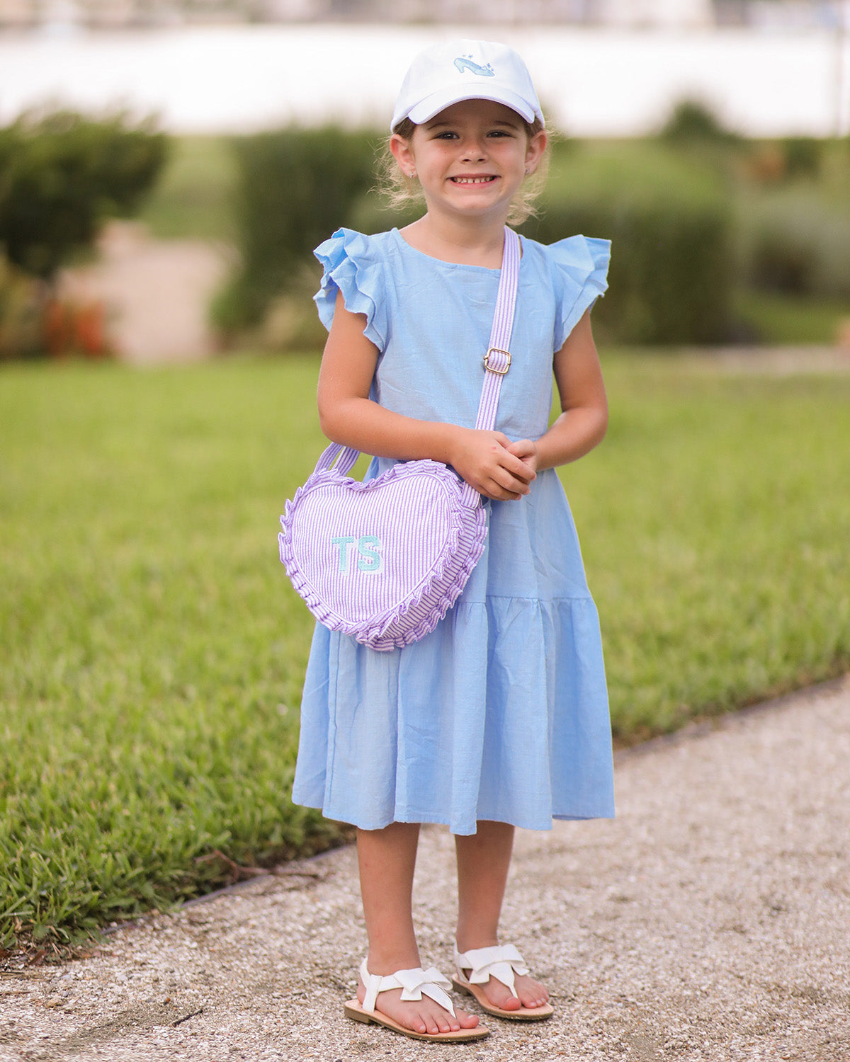 Little girl wearing a white baseball hat with glass slipper embroidery