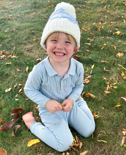 Boy wearing a bobble hat with golf club motif