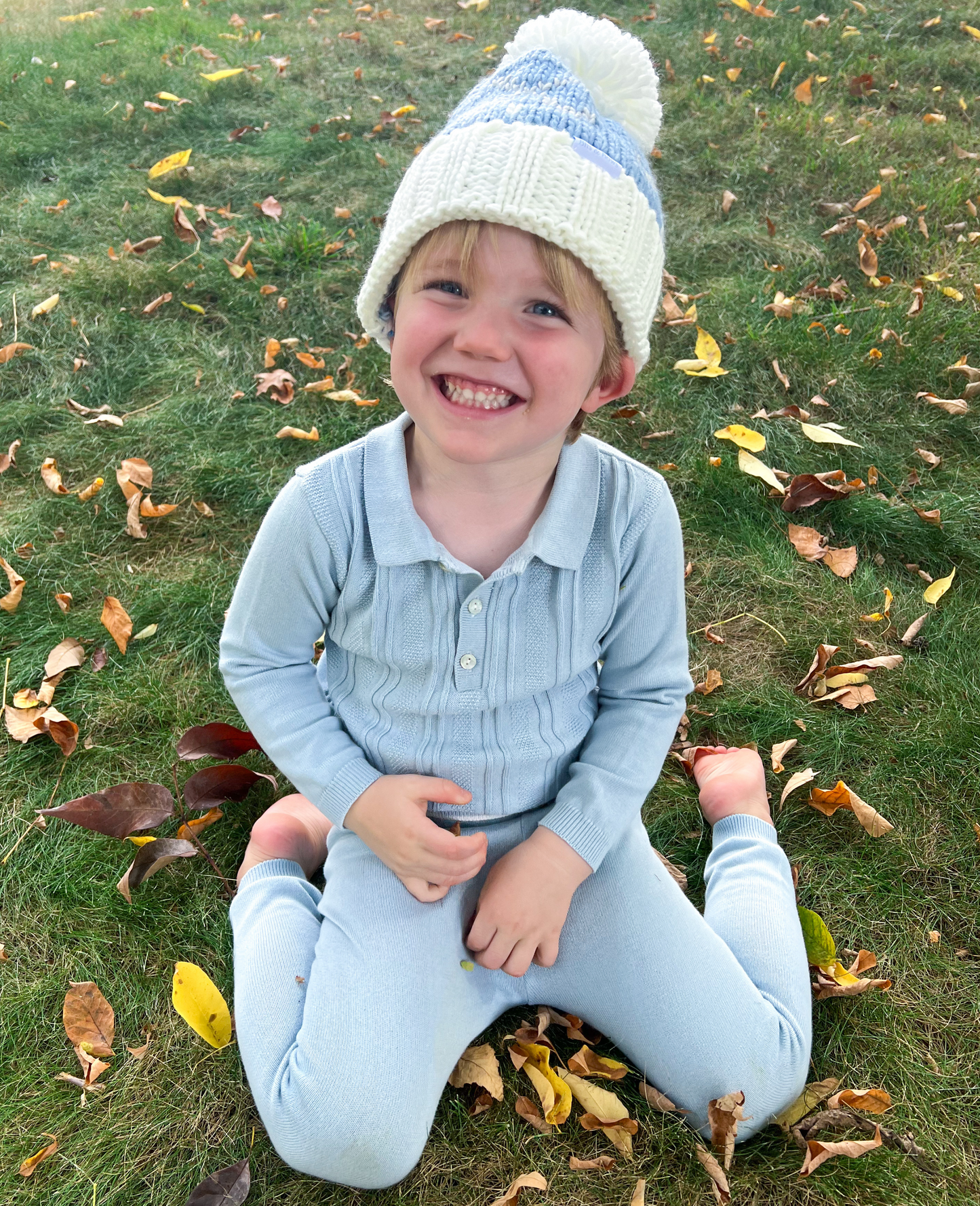 Boy wearing a bobble hat with golf club motif