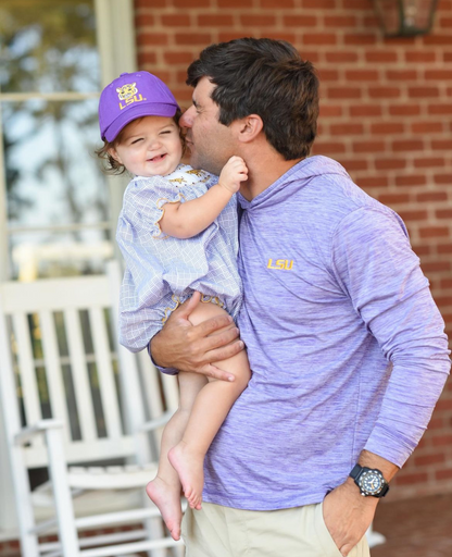 Father with baby girl wearing purple LSU Tigers baseball hat