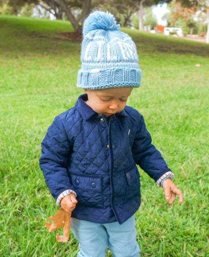 Little boy wearing a blue "lil bro" bobble hat