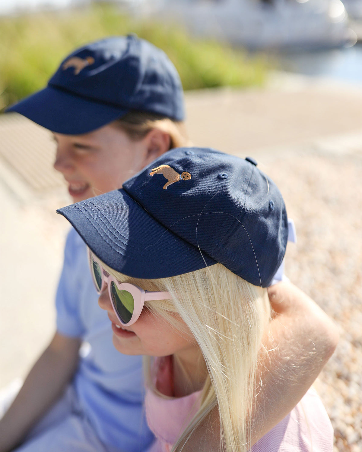 Boy and girl wearing coordinating baseball hats with dog embroidery