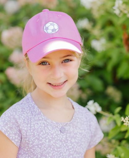 Girl wearing pink baseball hat with soccer ball embroidery