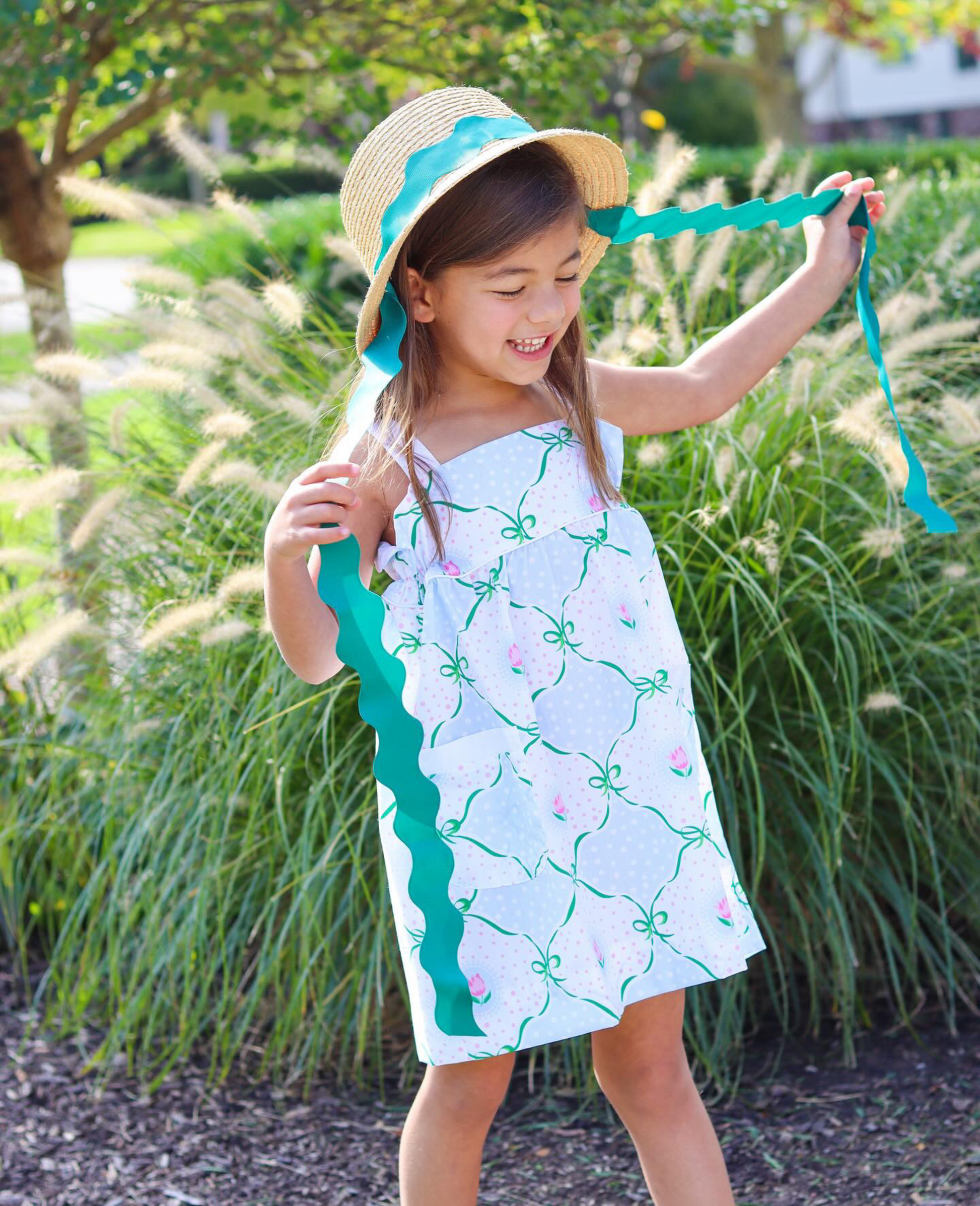 Girl wearing straw hat with green ric rac ribbon