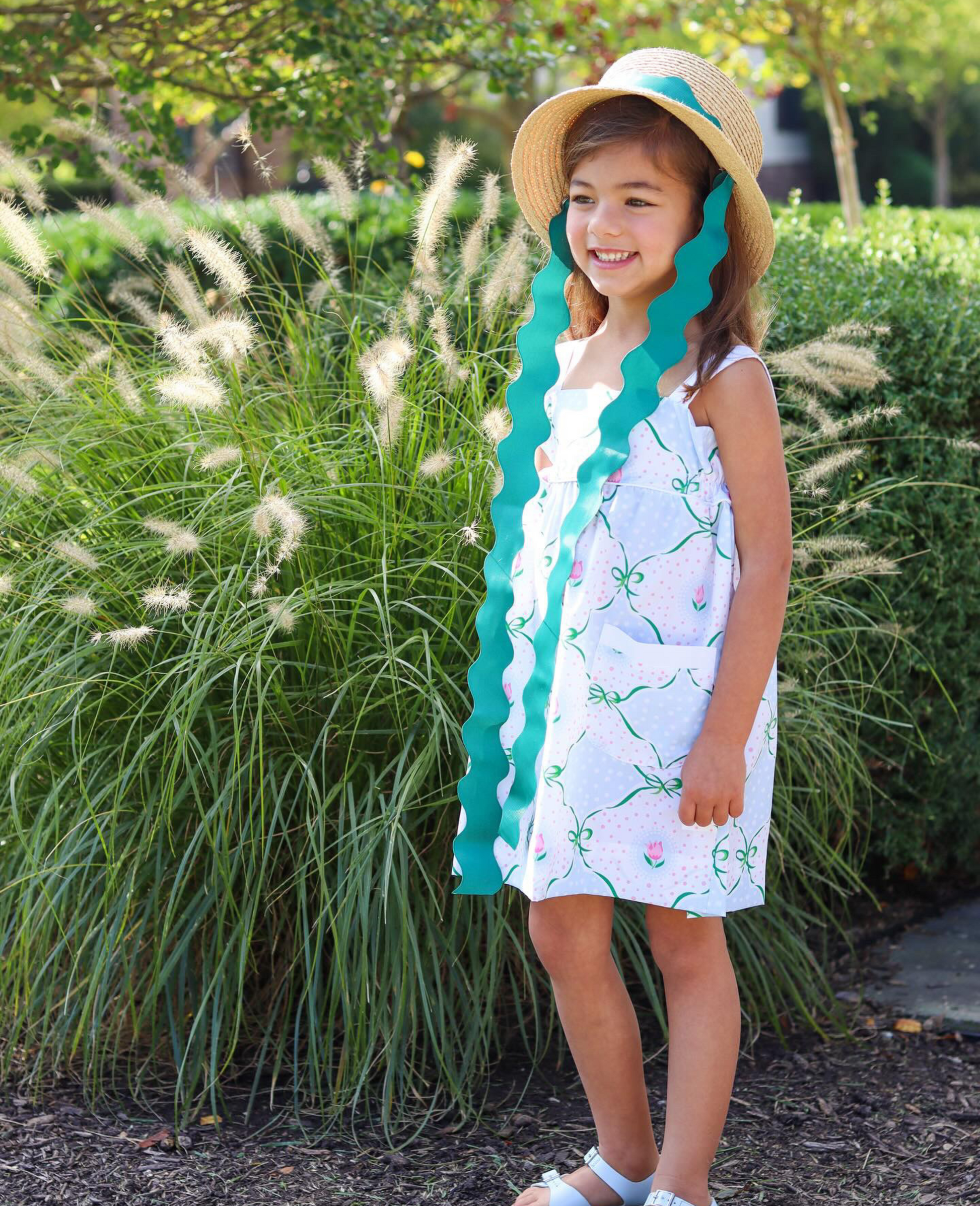 Girl wearing straw hat with green ric rac ribbon