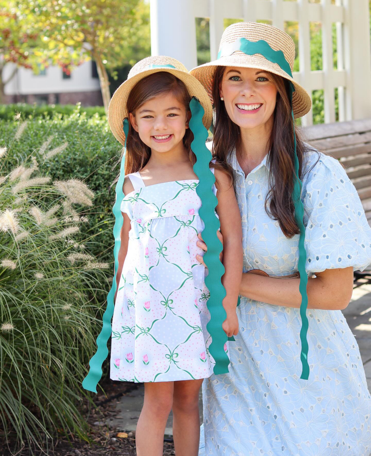 Mom and daughter wearing matching straw hats with green ric rac ribbon