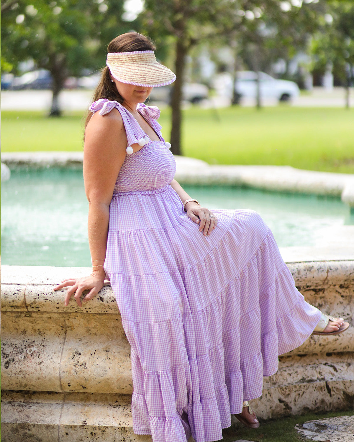 Woman wearing a straw visor with pink seersucker trim