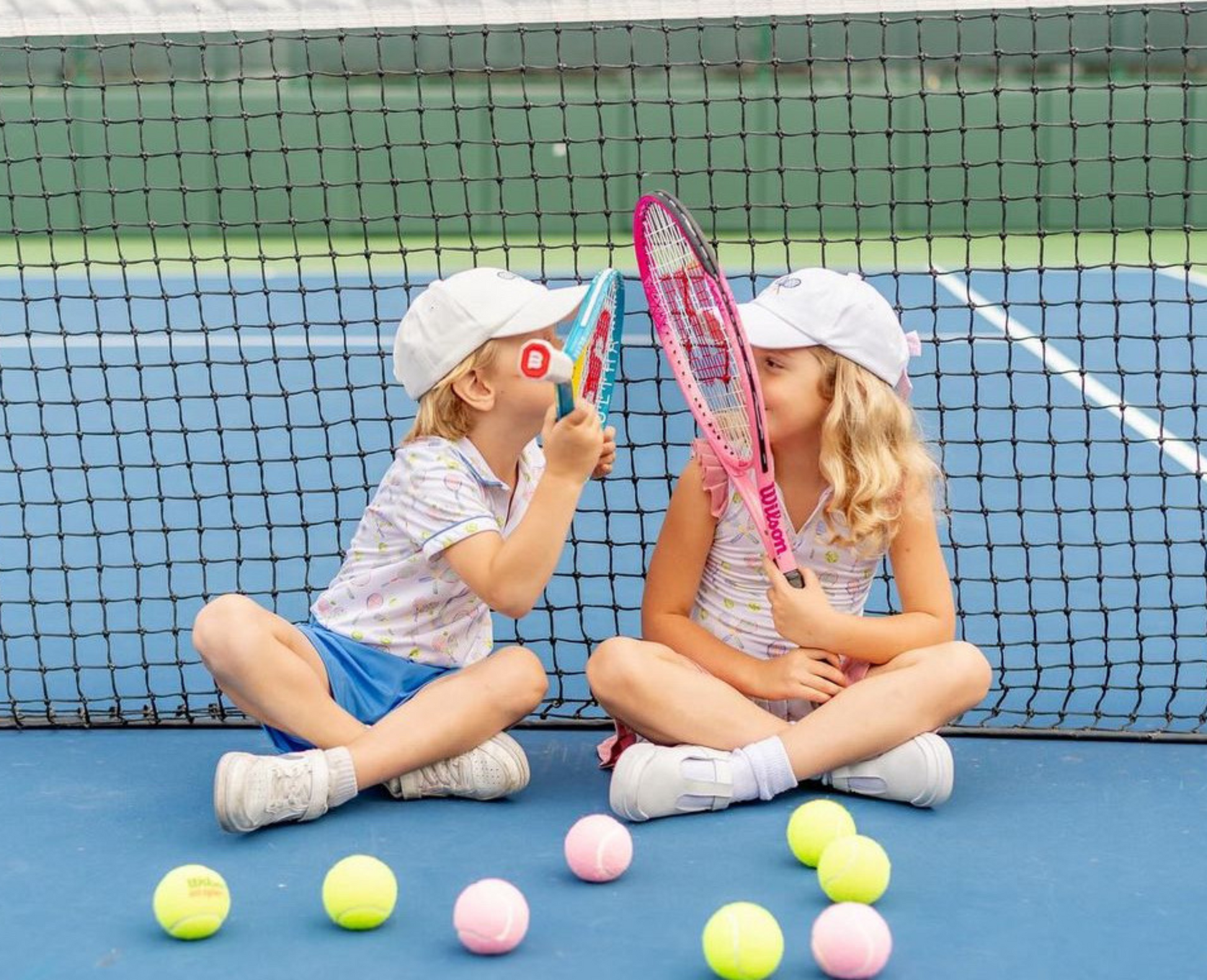 Kids wearing matching baseball hats with tennis embroidery