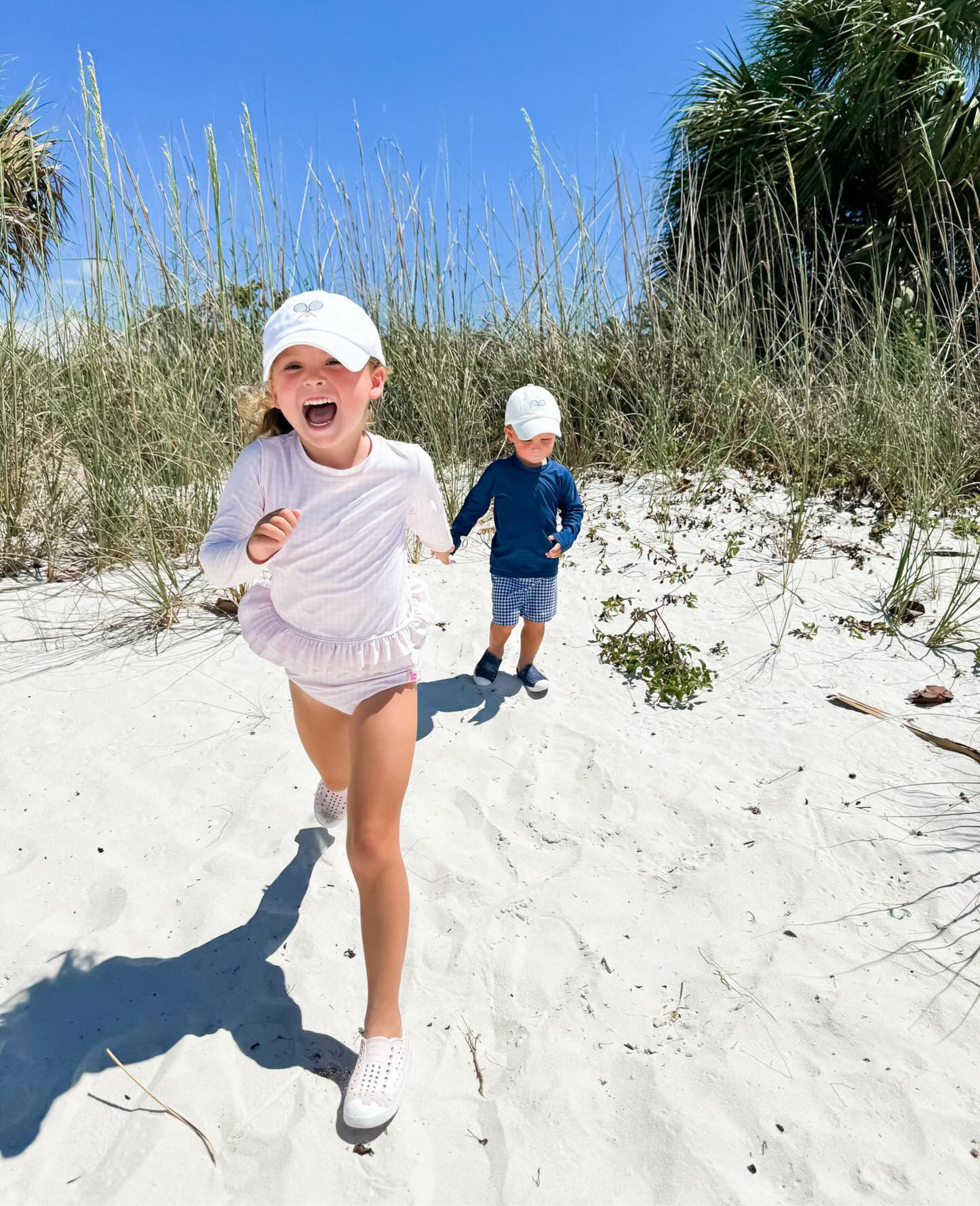 Kids wearing matching baseball hats with tennis embroidery