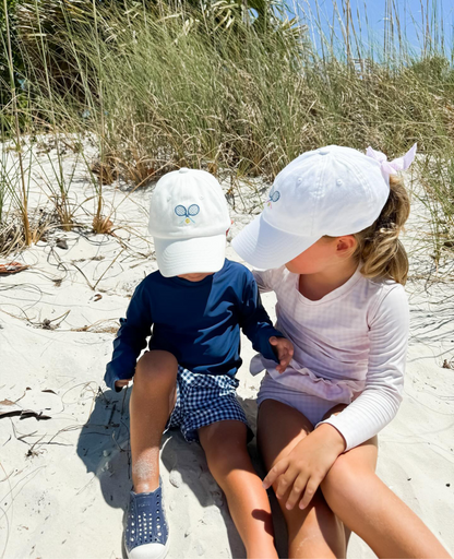 Kids wearing matching baseball hats with tennis embroidery