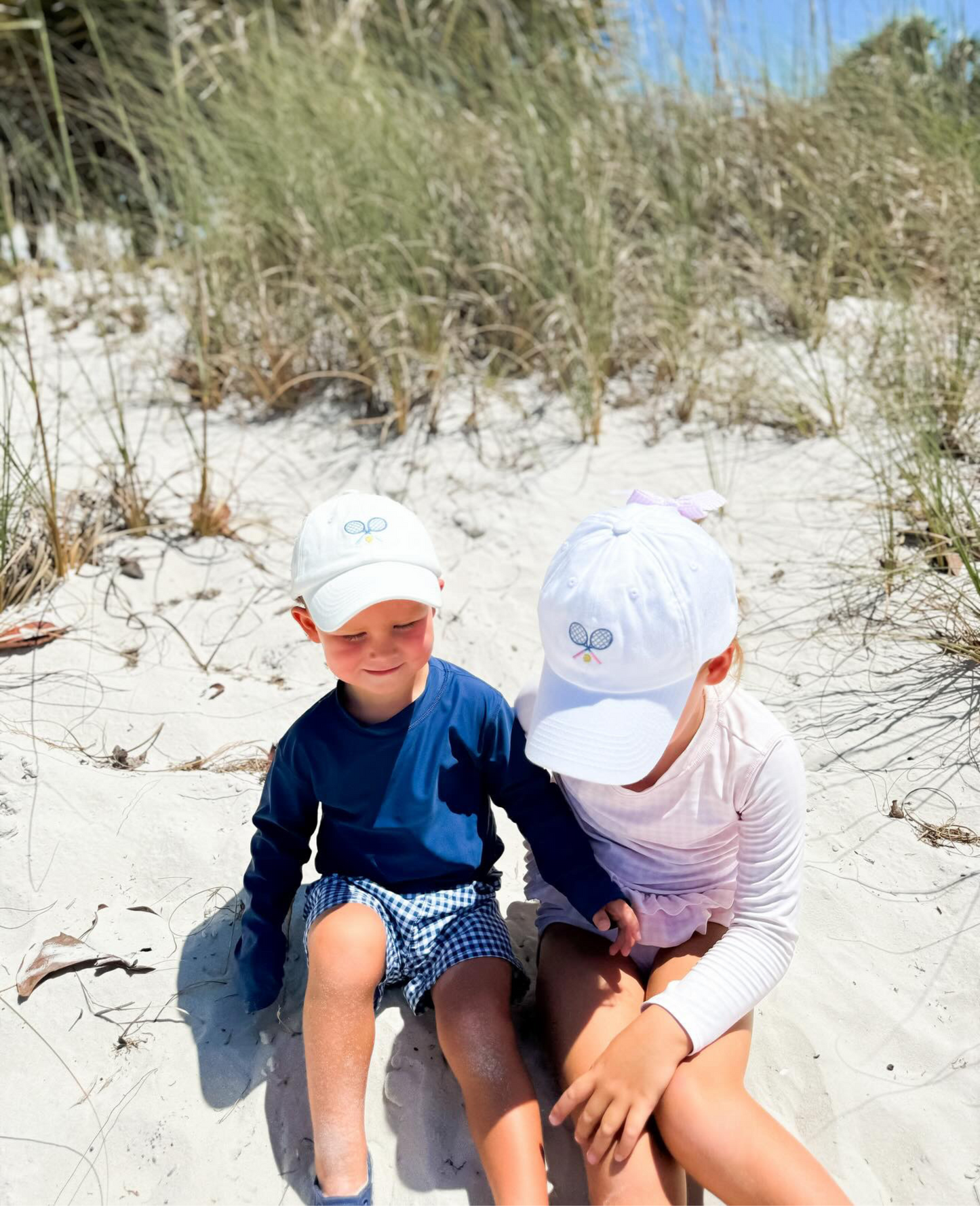 Kids wearing matching baseball hats with tennis embroidery